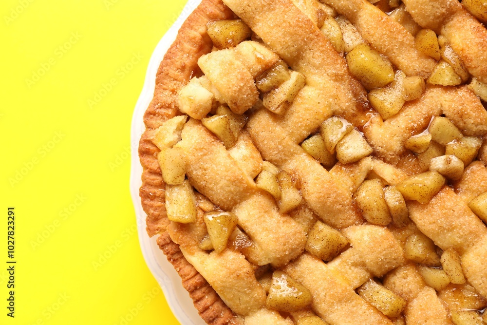 Tasty homemade apple pie on yellow background, top view. Space for text Tasty homemade apple pie on yellow background, top view. Space for text