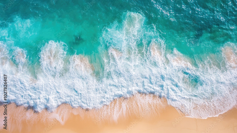 Sunny aerial view of turquoise water with waves splashing and a bright, sandy beach stretching out from the top view Sunny aerial view of turquoise water with waves splashing and a bright, sandy beach stretching out from the top view
