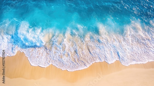 Fototapeta Naklejka Na Ścianę i Meble -  Top view of clear blue sea and golden sand, with sunlight sparkling on the waves and creating a beautiful coastal scene