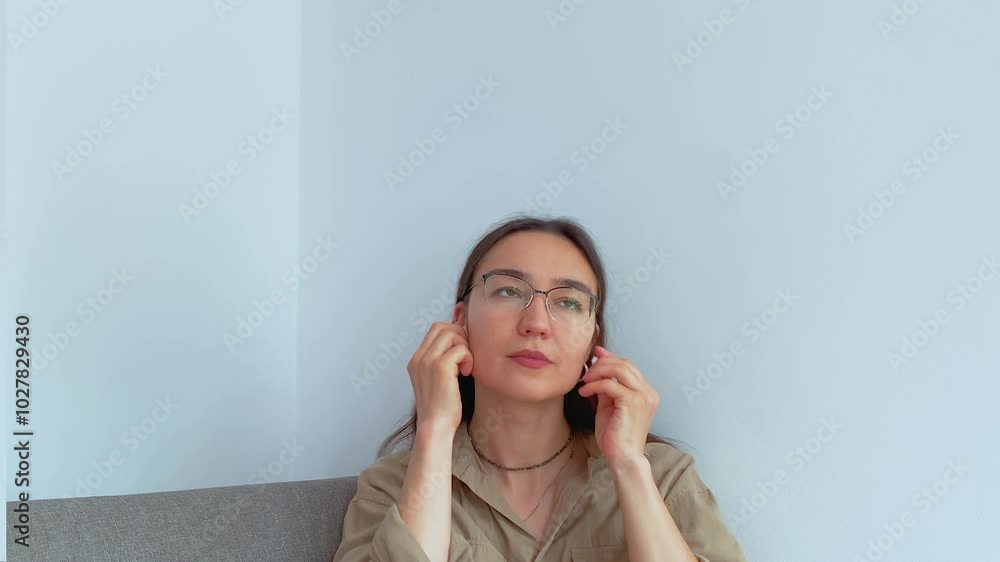 A young attractive girl in headphones is talking on the phone . A young attractive girl in headphones is talking on the phone .