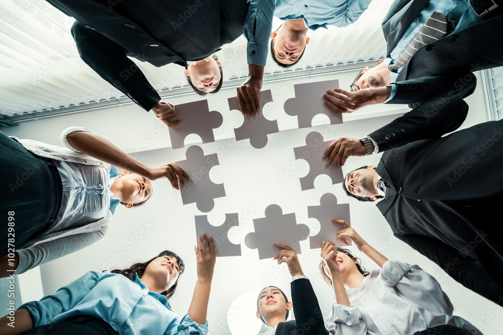 Multiethnic business people holding jigsaw pieces and merge them together as effective solution solving teamwork, shared vision and common goal combining diverse talent. Below view. Habiliment
