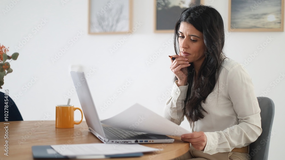 Businesswoman working from home having a difficult decision to make Businesswoman working from home having a difficult decision to make