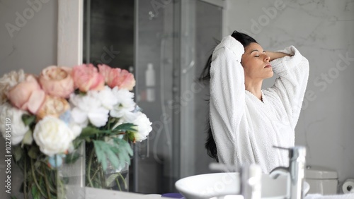 Beautiful woman drying her hair with a towel in bathroom after shower