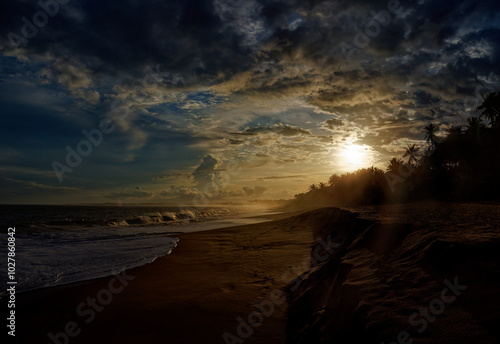 Beach in Sri Lanka (Ceylon) with the waves and sandy coast, sunset or sunrise landscape with beautiful dramatic sky. Blue Indian ocean photo