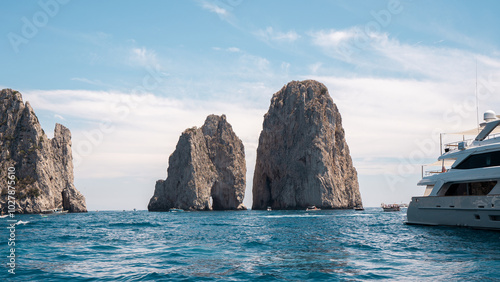 Faraglioni Rock Formation and Yacht on the Blue Waters of Capri, Italy – A Stunning Coastal View