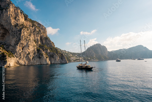 Sailboat and Yachts Docked Near the Rocky Coast of Capri, Italy – Idyllic Mediterranean Scene