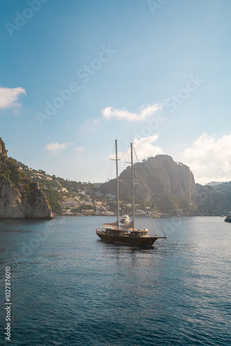 Sailboat and Yachts Docked Near the Rocky Coast of Capri, Italy – Idyllic Mediterranean Scene