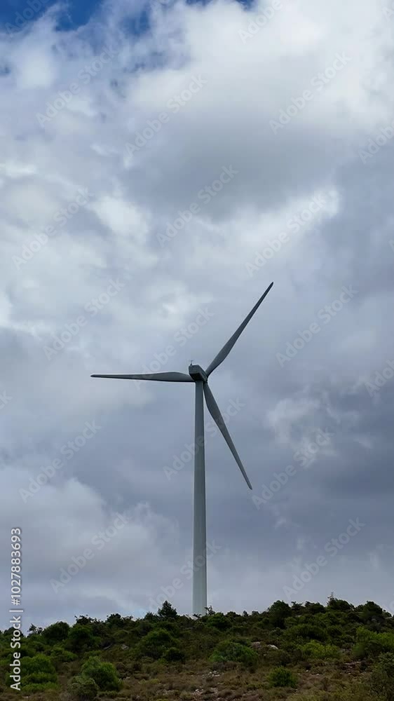 Wind turbine for alternative electricity, energy and power surrounded by stormy clouds and landscape, ecology and environment concept Wind turbine for alternative electricity, energy and power surrounded by stormy clouds and landscape, ecology and environment concept
