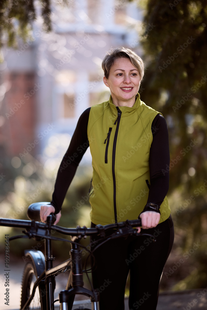 Fototapeta premium Woman Walking With Bicycle In City Park