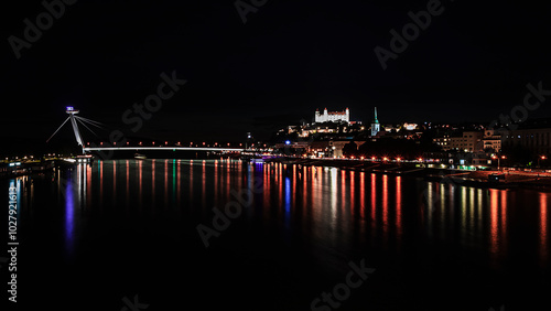 Photography Bratislava night landscape with famous SNP bridge and castle overlooking the hil