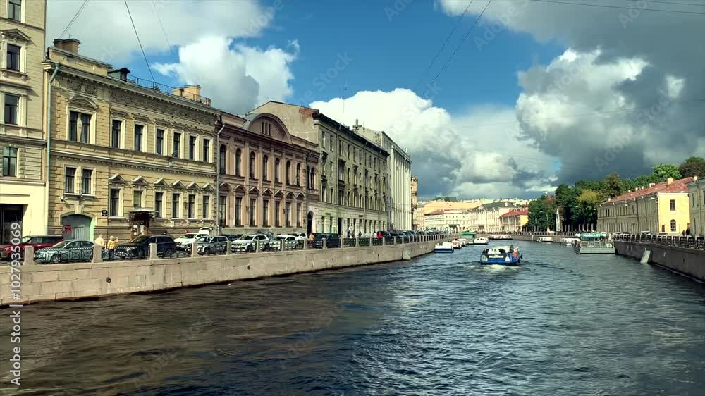 A river tram glides along a peaceful city canal, flanked by historic buildings on both sides. The journey highlights the charm of the old city architecture and scenic waterfront views. A river tram glides along a peaceful city canal, flanked by historic buildings on both sides. The journey highlights the charm of the old city architecture and scenic waterfront views.