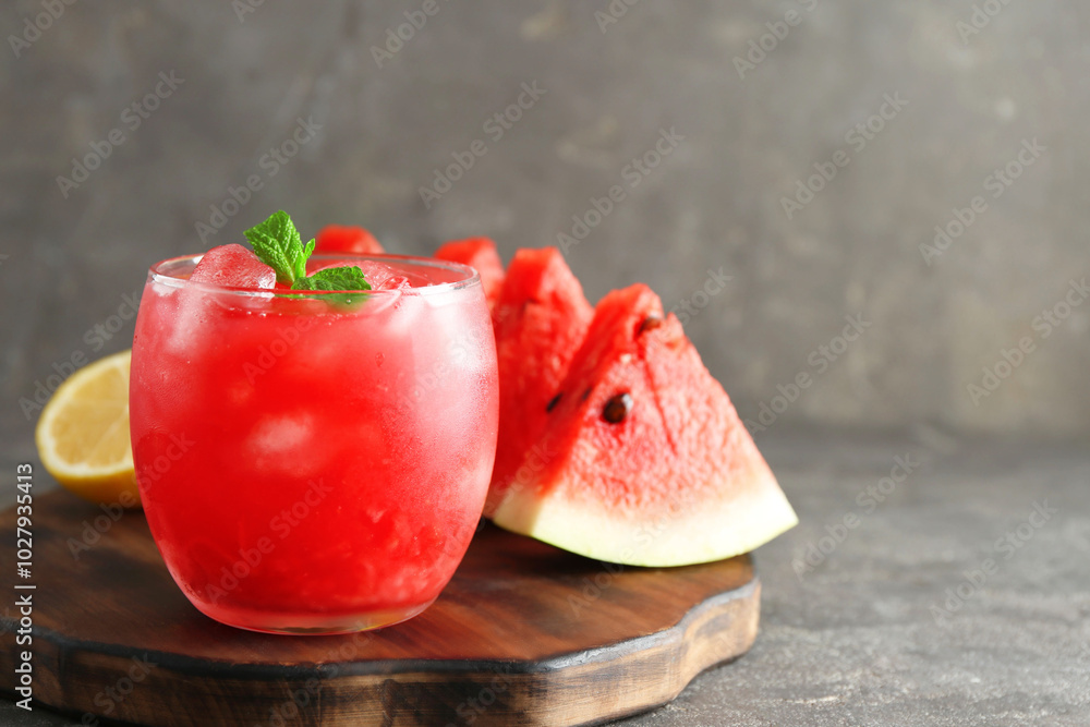 Tasty watermelon drink in glass, fresh fruits and mint on grey table, closeup Tasty watermelon drink in glass, fresh fruits and mint on grey table, closeup