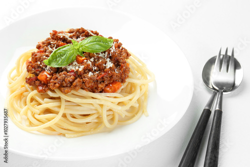 Delicious pasta bolognese and cutlery on white table, closeup