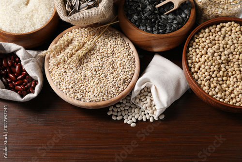 Different types of cereals, seeds and legumes on wooden table, flat lay