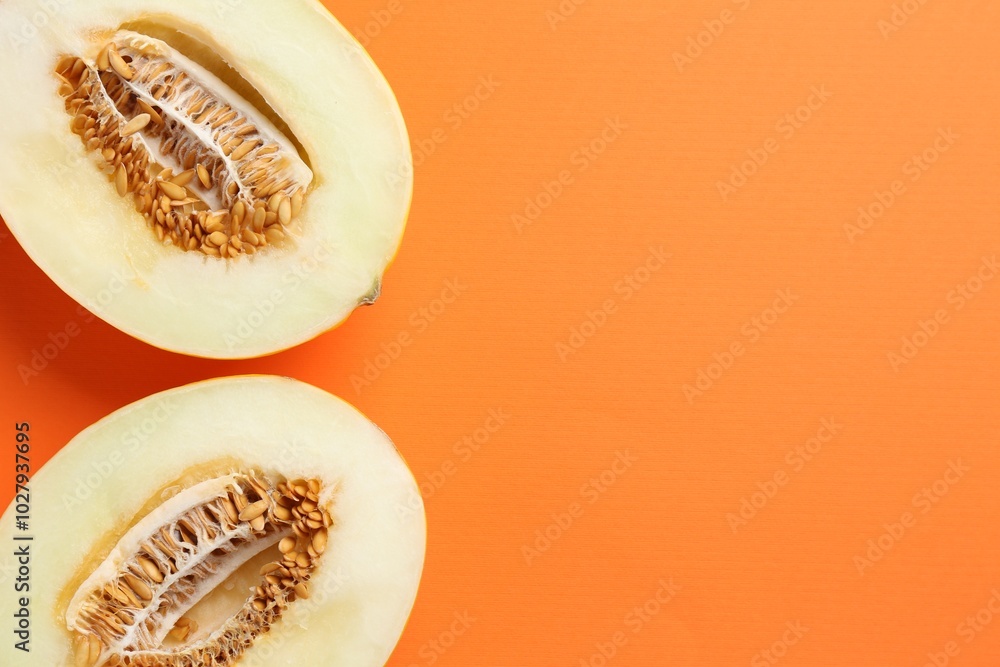 Halves of fresh melon on orange background, top view. Space for text Halves of fresh melon on orange background, top view. Space for text
