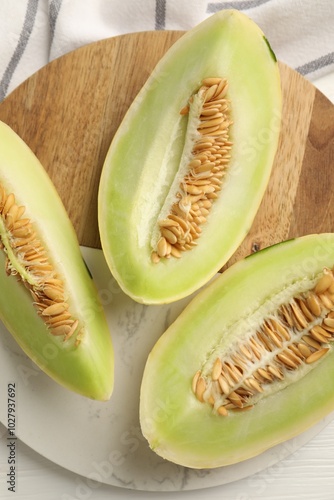 Fresh cut honeydew melon on white wooden table, top view photo