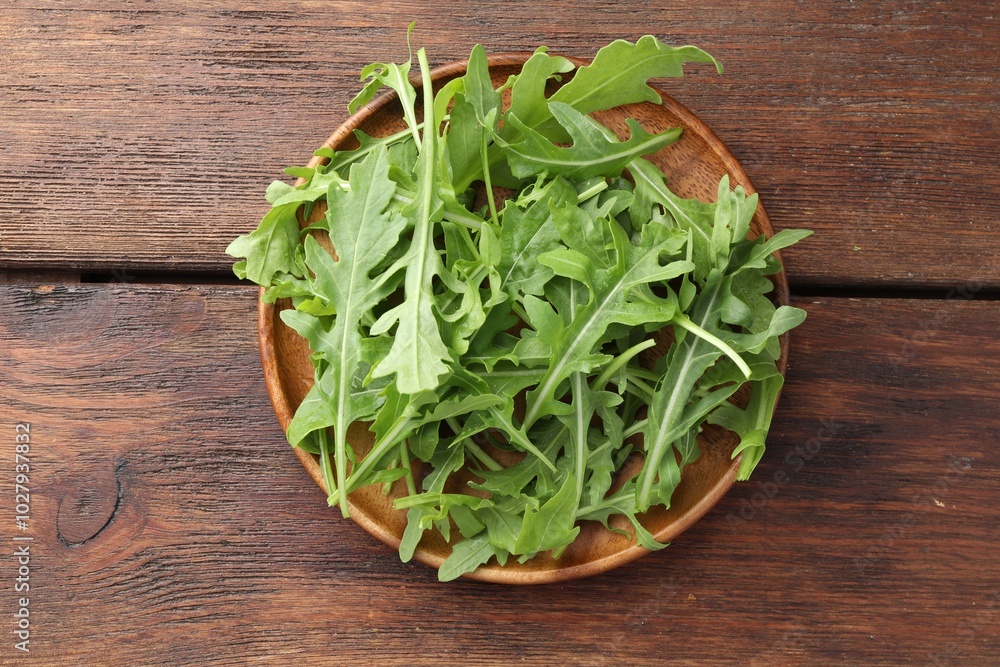 Fresh green arugula leaves on wooden table, top view Fresh green arugula leaves on wooden table, top view