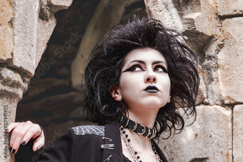 Ritratto di giovane donna in stile dark gothic con trucco nero, rossetto nero e piercing al naso. Bellissima ragazza italiana mora con riflessi viola. Ragazza Trad goth. Ritratto in primo piano