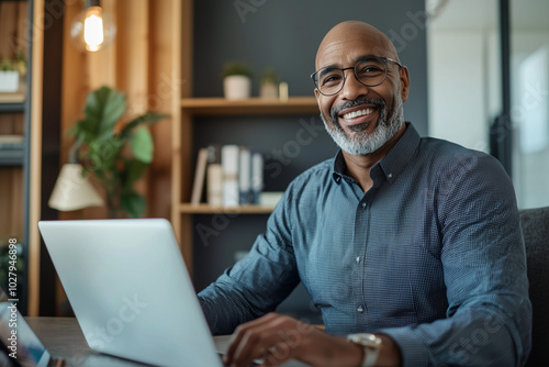 Smiling Businessman Working on Laptop in Office