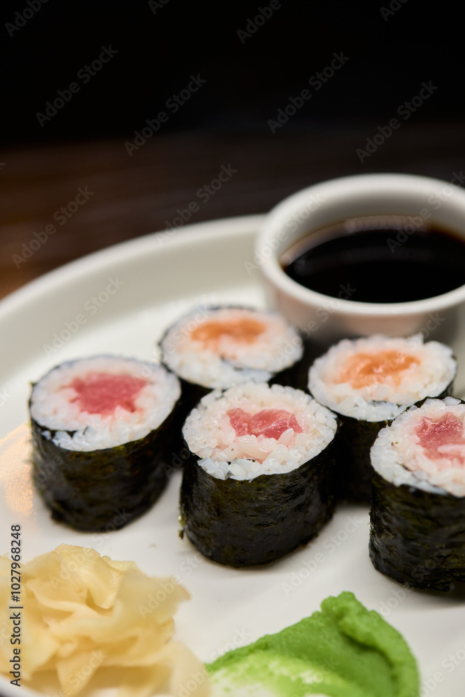 A Beautiful Plate Filled with Delicious Sushi Rolls Accompanied by Soy Sauce for Dipping A Beautiful Plate Filled with Delicious Sushi Rolls Accompanied by Soy Sauce for Dipping