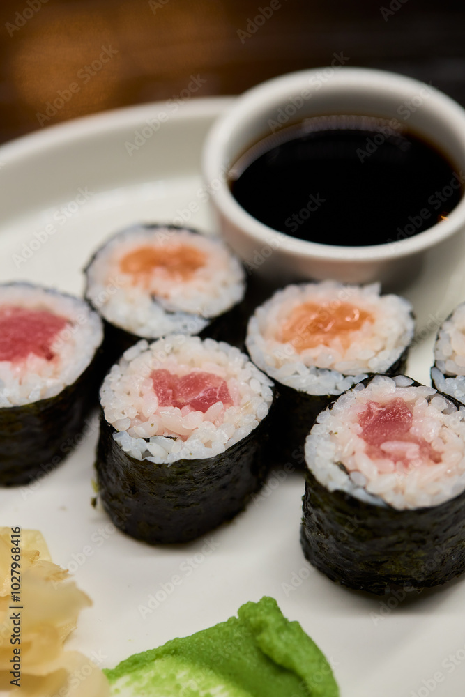 A Beautiful Plate Filled with Delicious Sushi Rolls Accompanied by Soy Sauce for Dipping A Beautiful Plate Filled with Delicious Sushi Rolls Accompanied by Soy Sauce for Dipping