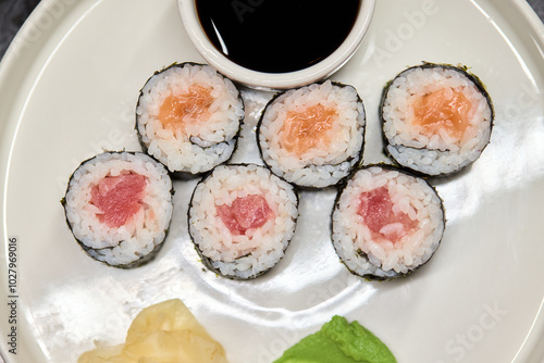 A Beautiful Plate Filled with Delicious Sushi Rolls Accompanied by Soy Sauce for Dipping photo