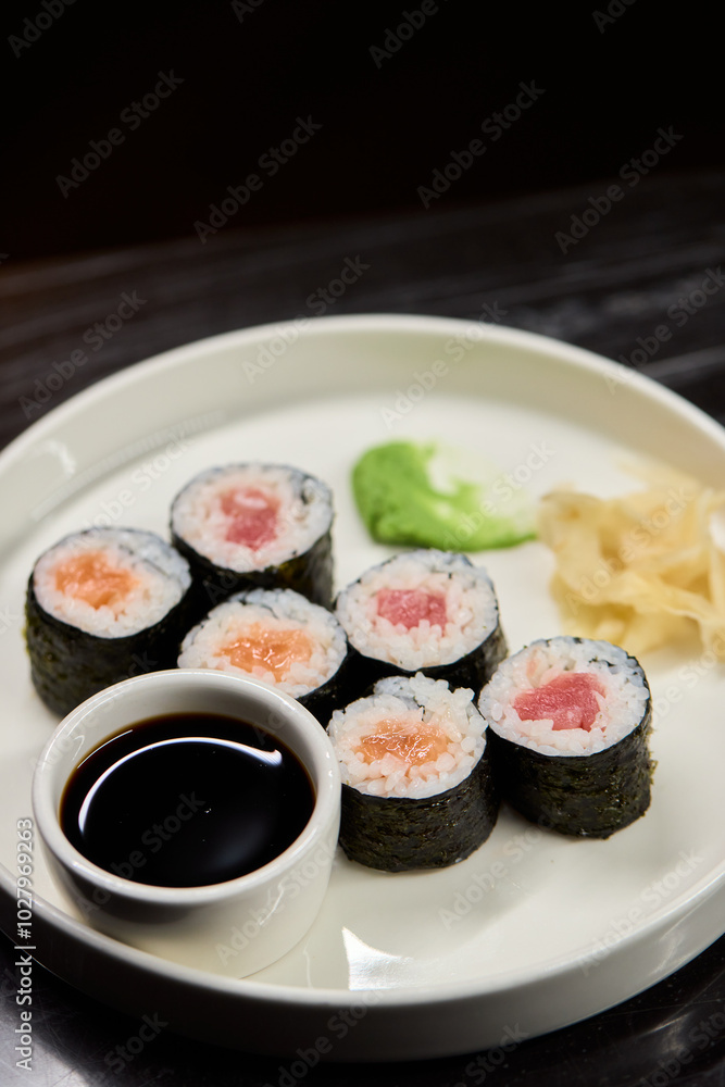 A Beautiful Plate Filled with Delicious Sushi Rolls Accompanied by Soy Sauce for Dipping A Beautiful Plate Filled with Delicious Sushi Rolls Accompanied by Soy Sauce for Dipping