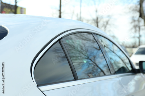 Modern car with tinting foil on window outdoors, closeup photo