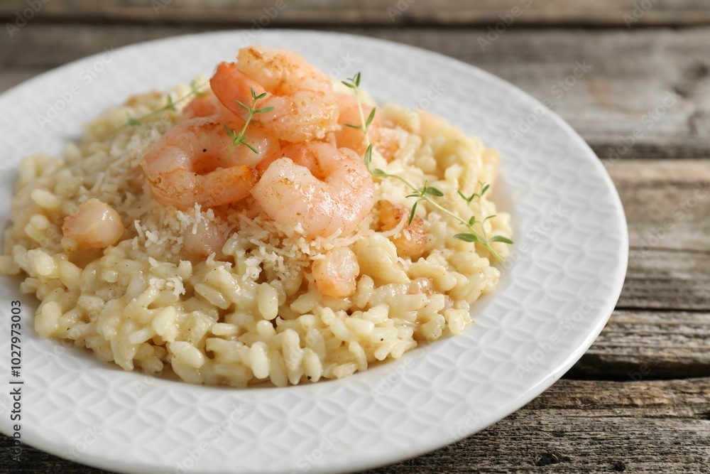 Delicious risotto with shrimps and cheese on wooden table, closeup Delicious risotto with shrimps and cheese on wooden table, closeup