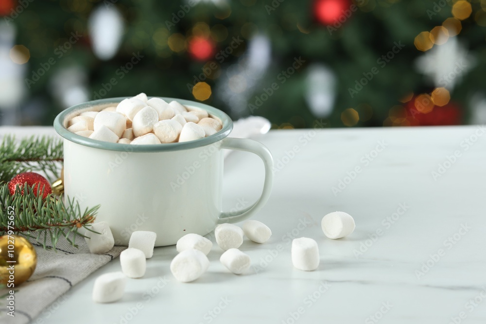 Tasty hot cocoa drink with marshmallows in mug and Christmas decor on white table against blurred lights, closeup. Space for text Tasty hot cocoa drink with marshmallows in mug and Christmas decor on white table against blurred lights, closeup. Space for text