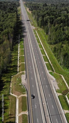 Trucks and cars at the highway in the forest. Aerial view.