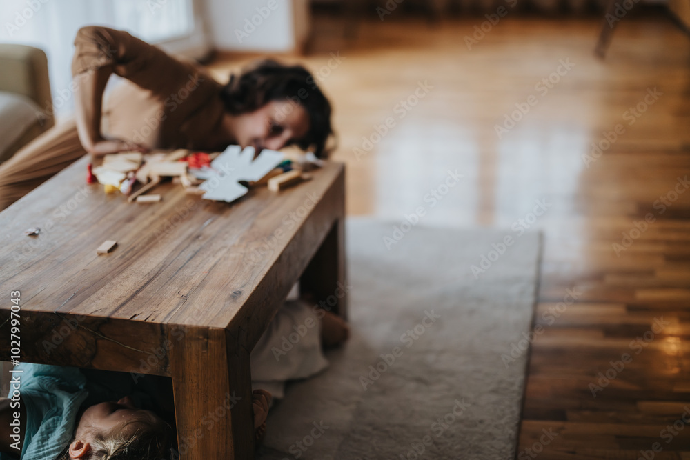 A mother and child enjoy a playful moment of hide and seek in a cozy living room, fostering family bonds and joy. A mother and child enjoy a playful moment of hide and seek in a cozy living room, fostering family bonds and joy.