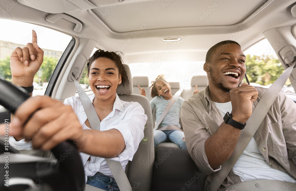 Cheerful Black Family Singing Riding New Car Having Fun Enjoying Road Trip On Vacation. Parents And Daughter Traveling By Automobile In Summer. Selective Focus Cheerful Black Family Singing Riding New Car Having Fun Enjoying Road Trip On Vacation. Parents And Daughter Traveling By Automobile In Summer. Selective Focus