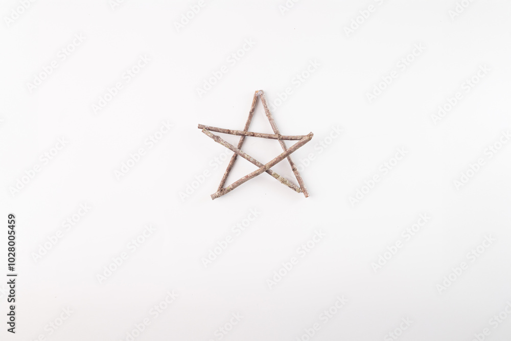 Five pointed star shape made from five small sticks on plain light background. Simple representation of star using natural materials. Rustic, handmade, eco-friendly, festive decoration Five pointed star shape made from five small sticks on plain light background. Simple representation of star using natural materials. Rustic, handmade, eco-friendly, festive decoration