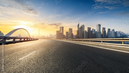 asphalt highway road and bridge with modern city skyline at sunrise