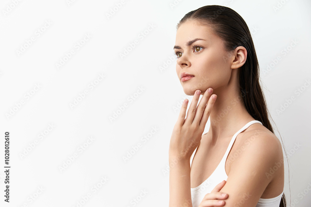 Portrait of a thoughtful young woman with long hair, posed against a clean white background, showcasing a contemplative expression and natural beauty