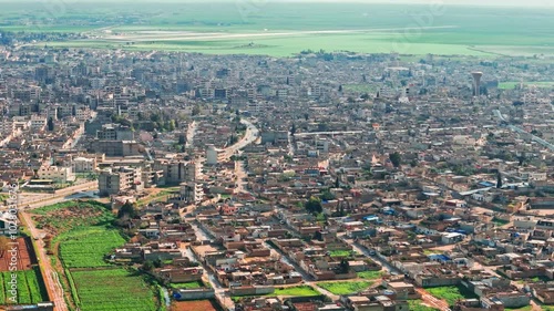 This aerial footage of Qamishli, Syria, captures houses, streets, and daily life, offering a glimpse into the city’s reality. Ideal for projects on urban life or Middle Eastern communities. photo