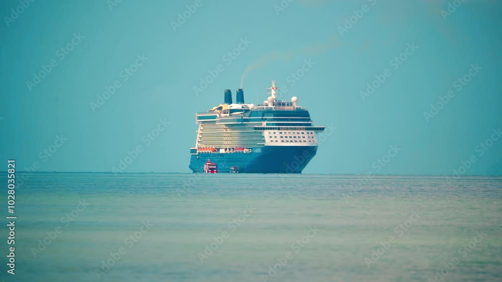 Large cruise ship sailing in the calm sea on a clear day near a tropical coastline Large cruise ship sailing in the calm sea on a clear day near a tropical coastline