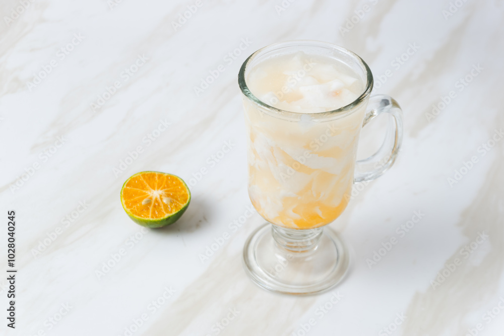 Es Kelapa Jeruk, a typical Indonesian drink made from fresh oranges squeezed with grated young coconut. with copy space. perfect for recipe, article, catalogue, or any commercial purposes. Es Kelapa Jeruk, a typical Indonesian drink made from fresh oranges squeezed with grated young coconut. with copy space. perfect for recipe, article, catalogue, or any commercial purposes.