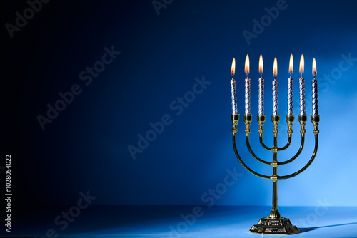 Obraz na płótnie Hanukkah Menorah with burning candles on dark blue background with copy space for text