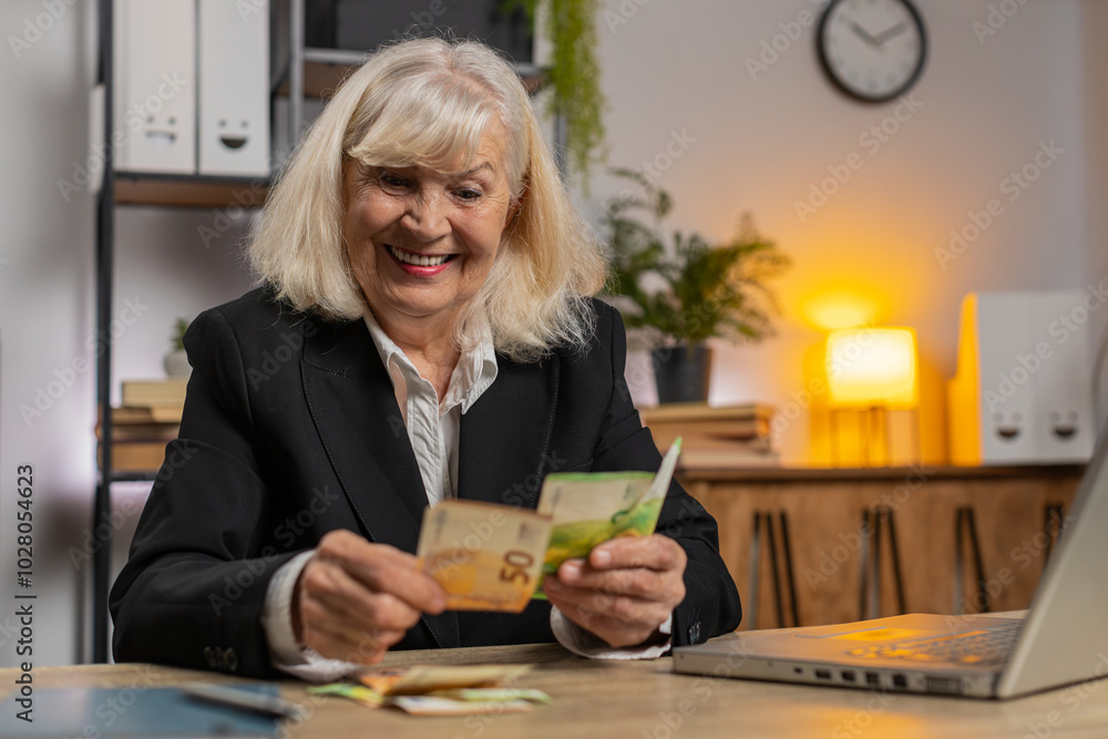 Excited senior businesswoman counting euro cash money dollar checking salary enjoy richness at workplace. Happy freelancer girl calculating currency profit financial savings at home office desk. Excited senior businesswoman counting euro cash money dollar checking salary enjoy richness at workplace. Happy freelancer girl calculating currency profit financial savings at home office desk.
