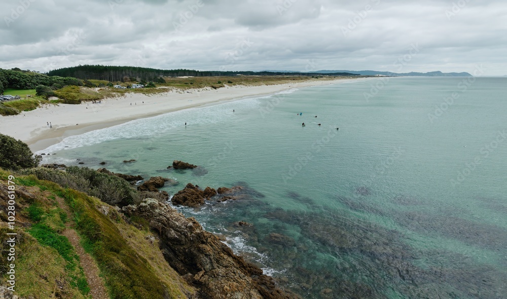 Rocky and sandy coastline of Te Arai Beach on a calm sunny day, Auckland, New Zealand. Rocky and sandy coastline of Te Arai Beach on a calm sunny day, Auckland, New Zealand.