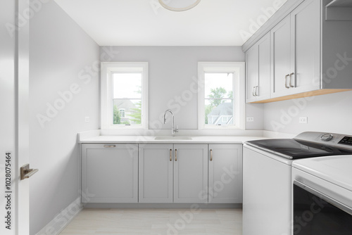 A laundry room with grey cabinets, white marble countertop, white washer and dryer, and a brown tiled floor. No brands or labels.