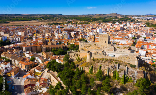 Panoramic aerial view of Almansa cityscape overlooking Church of la Asuncion and medieval Arab fortress on stone hill, Albacete, Spain.. photo