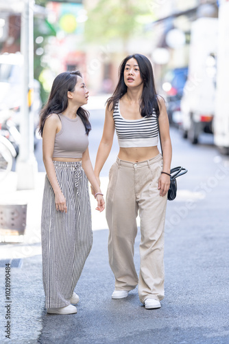 Two Taiwanese women in their 30s wearing casual outfits walk along Dihua Street in Taipei City, Taiwan, in September.