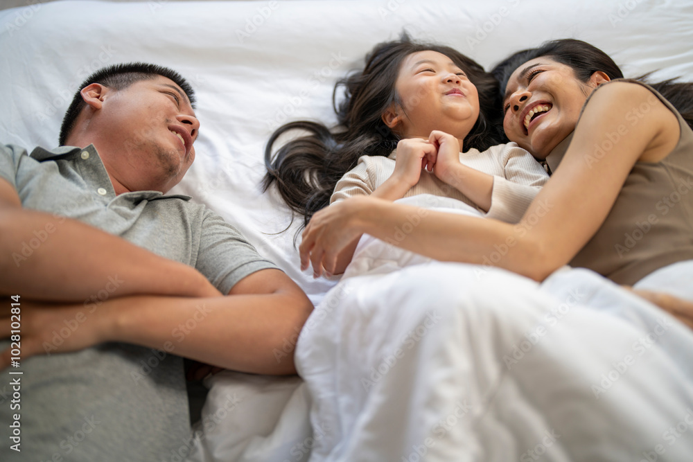 A joyful mother and daughter laughing together while lying on a bed. The playful moment showcases their strong bond and happiness in a comfortable home setting, surrounded by natural decor. A joyful mother and daughter laughing together while lying on a bed. The playful moment showcases their strong bond and happiness in a comfortable home setting, surrounded by natural decor.