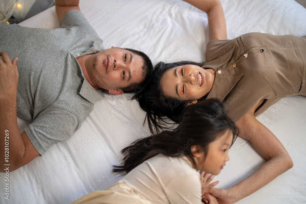 A joyful mother and daughter laughing together while lying on a bed. The playful moment showcases their strong bond and happiness in a comfortable home setting, surrounded by natural decor. A joyful mother and daughter laughing together while lying on a bed. The playful moment showcases their strong bond and happiness in a comfortable home setting, surrounded by natural decor.