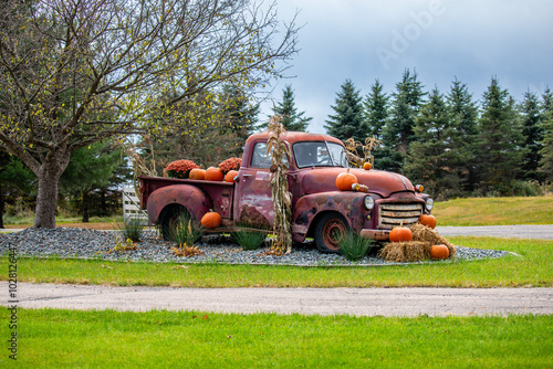 Old rusty truck decorated with pumpkins and cornstalks