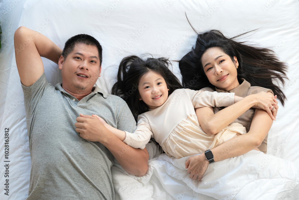 A joyful mother and daughter laughing together while lying on a bed. The playful moment showcases their strong bond and happiness in a comfortable home setting, surrounded by natural decor. A joyful mother and daughter laughing together while lying on a bed. The playful moment showcases their strong bond and happiness in a comfortable home setting, surrounded by natural decor.
