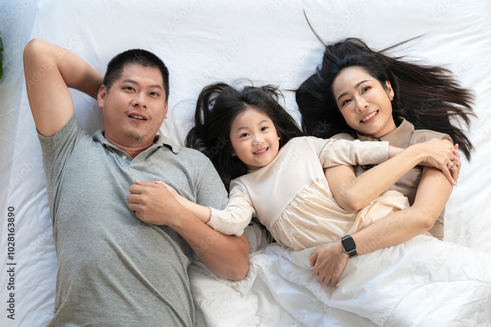 A joyful mother and daughter laughing together while lying on a bed. The playful moment showcases their strong bond and happiness in a comfortable home setting, surrounded by natural decor. A joyful mother and daughter laughing together while lying on a bed. The playful moment showcases their strong bond and happiness in a comfortable home setting, surrounded by natural decor.
